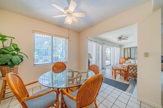 dining area featuring light tile patterned floors, a textured ceiling, and ceiling fan