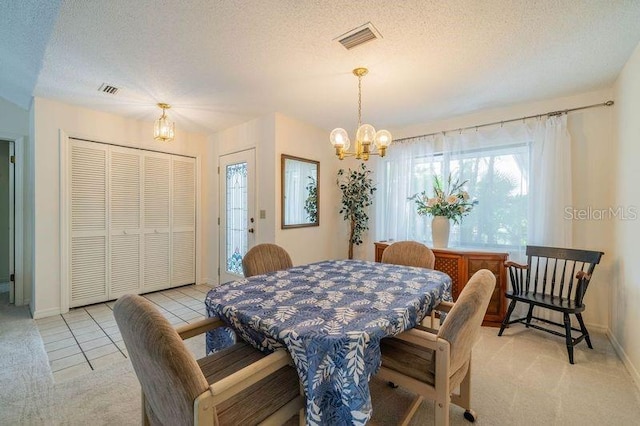 tiled dining room featuring a chandelier and a textured ceiling