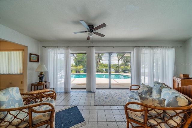 living room featuring light tile patterned flooring, ceiling fan, a healthy amount of sunlight, and a textured ceiling