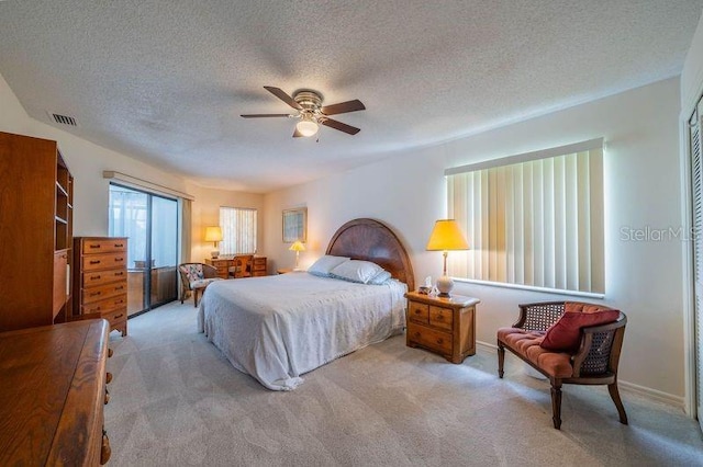 carpeted bedroom with a textured ceiling and ceiling fan