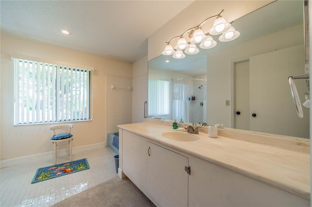 bathroom with vanity, tile patterned flooring, and a tile shower