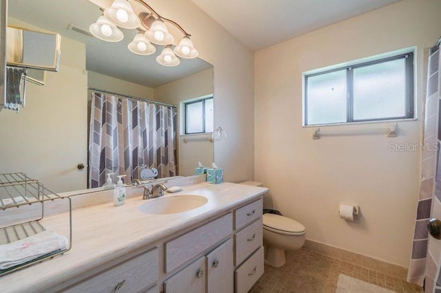 bathroom with an inviting chandelier, vanity, and toilet