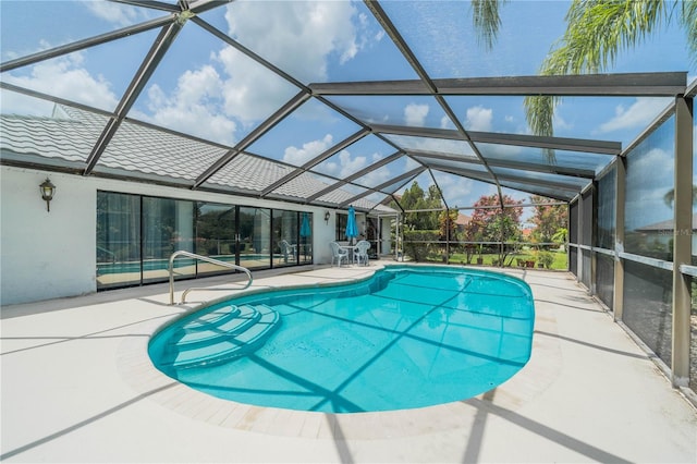 view of pool with a patio area and glass enclosure