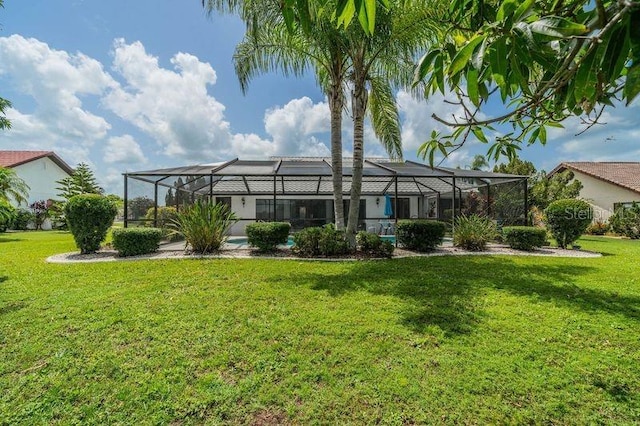 rear view of property featuring a lanai and a lawn