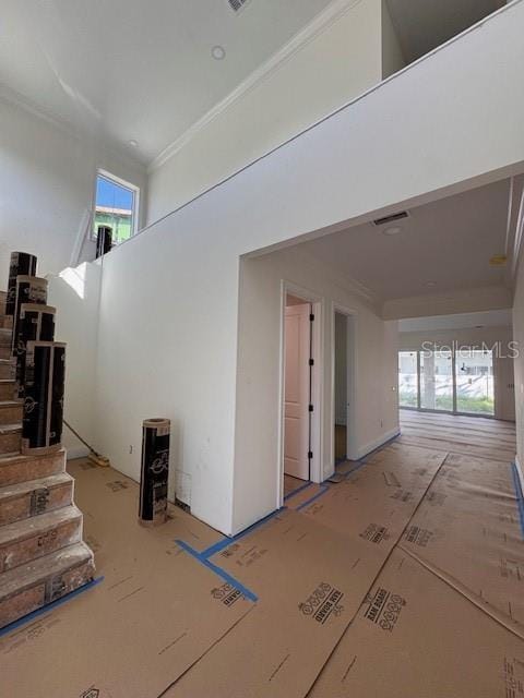 interior space with crown molding and a towering ceiling