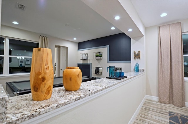 kitchen featuring light stone countertops and light wood-type flooring