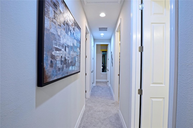 hallway featuring light colored carpet