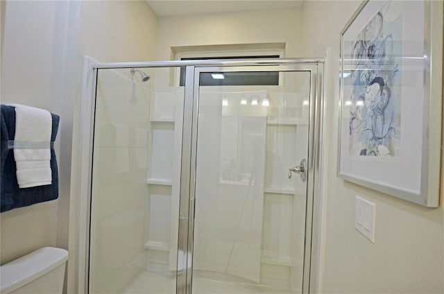 bathroom featuring walk in shower and toilet