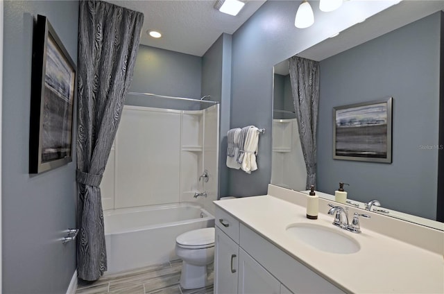 full bathroom with vanity, a textured ceiling, toilet, and washtub / shower combination