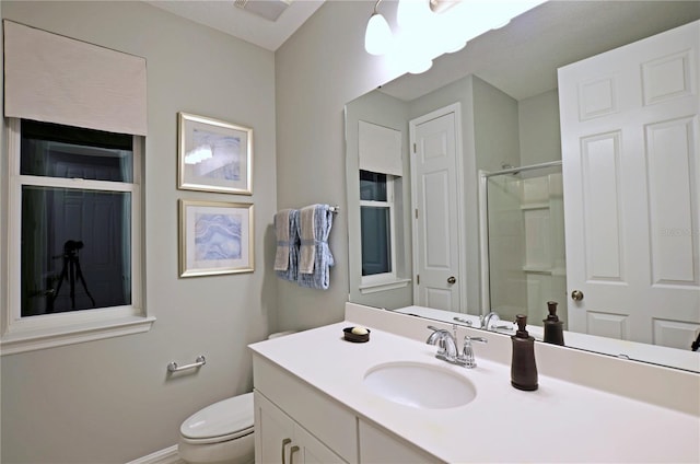 bathroom with vanity, a shower with shower door, and toilet