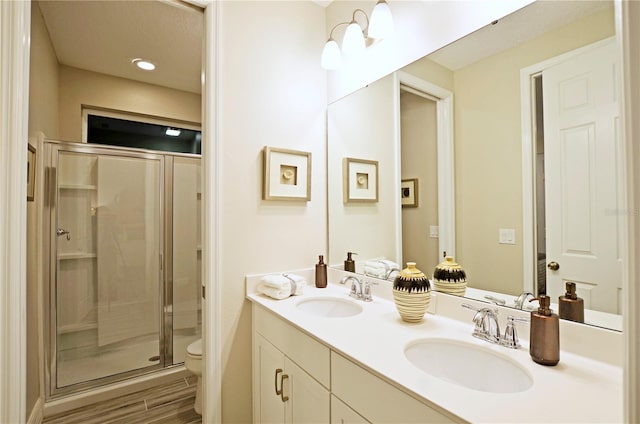 bathroom featuring vanity, hardwood / wood-style floors, an enclosed shower, and toilet