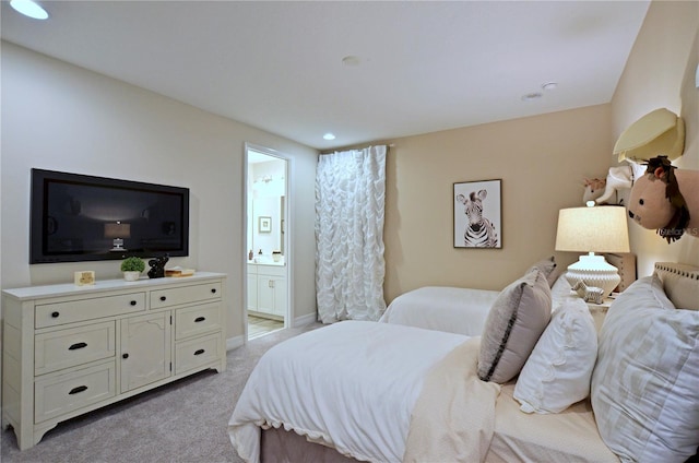 bedroom with light colored carpet and ensuite bathroom