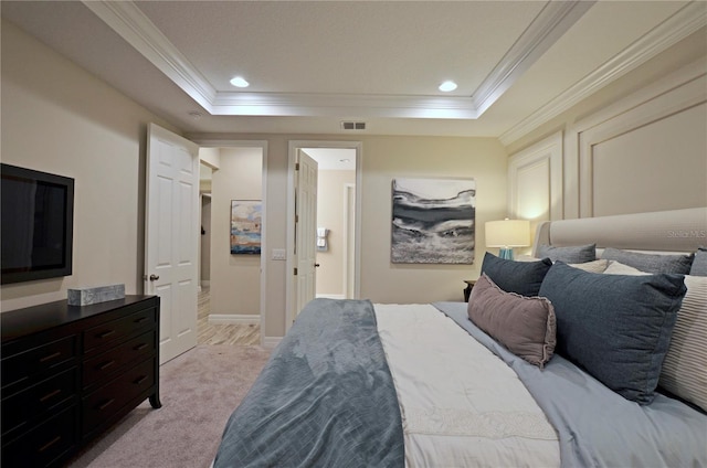 carpeted bedroom with ornamental molding and a tray ceiling