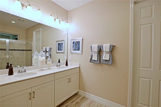 bathroom featuring vanity, hardwood / wood-style flooring, and a shower with door