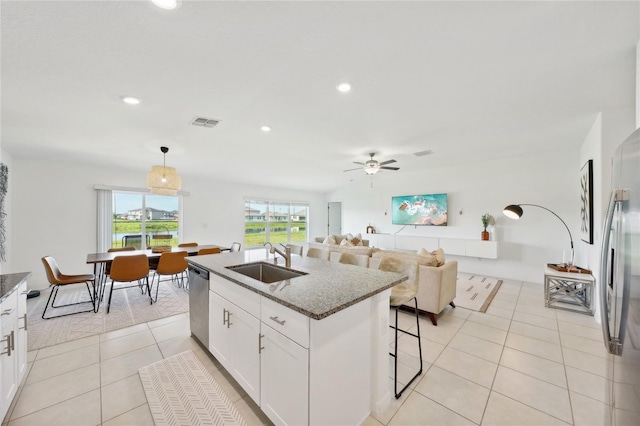 kitchen featuring white cabinetry, sink, a kitchen island with sink, light tile patterned floors, and appliances with stainless steel finishes