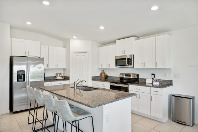 kitchen featuring white cabinets, appliances with stainless steel finishes, a center island with sink, and sink