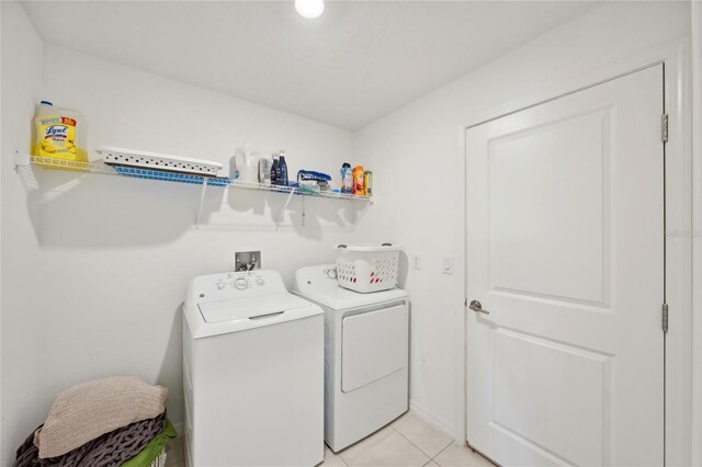 laundry area featuring separate washer and dryer and light tile patterned flooring