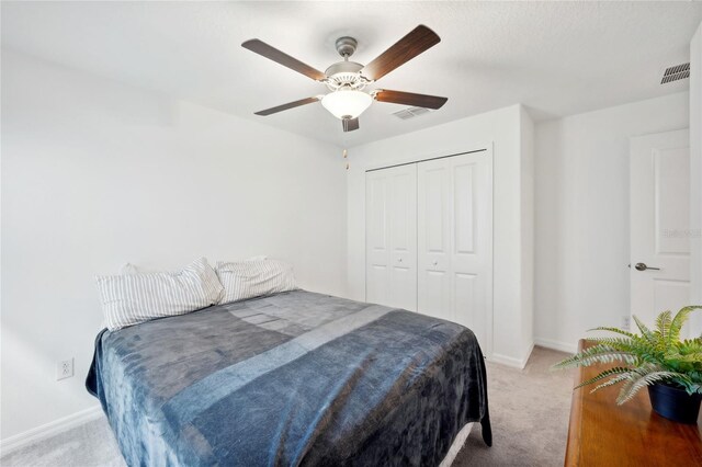 bedroom with light carpet, a closet, and ceiling fan