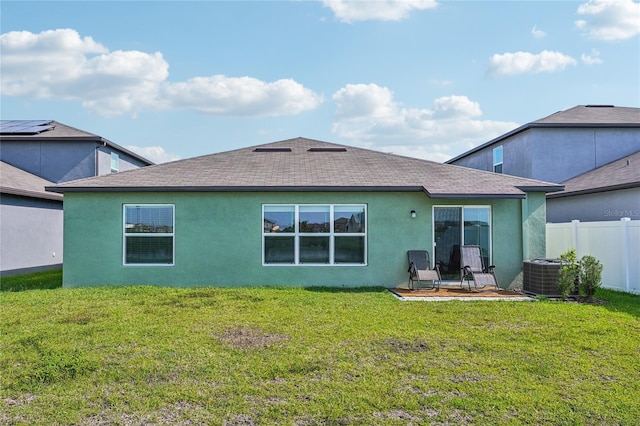 back of property with a lawn and cooling unit