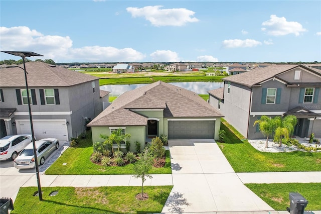 front of property with a garage, a water view, and a front lawn