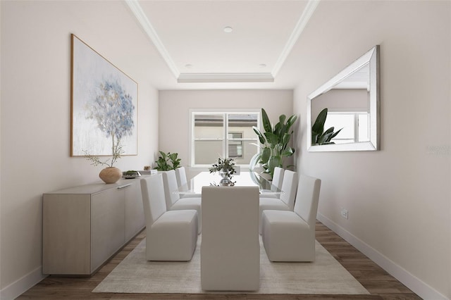 dining area featuring baseboards, ornamental molding, a raised ceiling, and wood finished floors