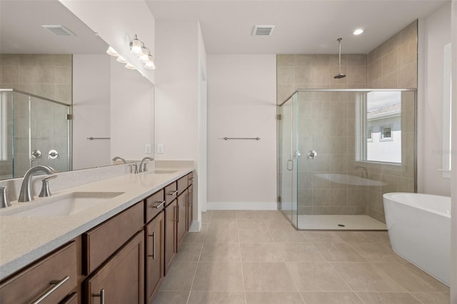 full bathroom with double vanity, a stall shower, visible vents, and a sink