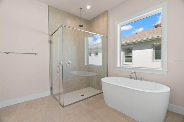 bathroom featuring tile patterned flooring and shower with separate bathtub