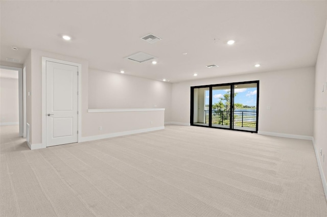 spare room featuring recessed lighting, visible vents, light carpet, and baseboards