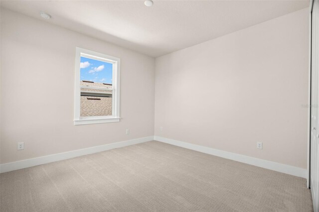 spare room featuring light colored carpet