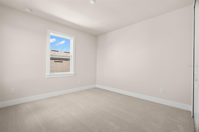 empty room featuring carpet flooring and baseboards