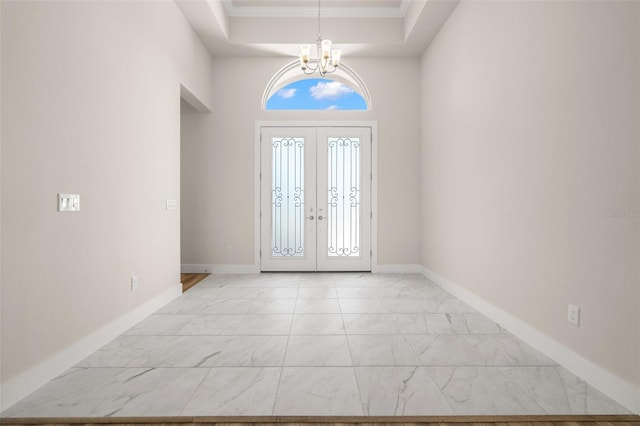 foyer entrance with a chandelier, marble finish floor, baseboards, and french doors