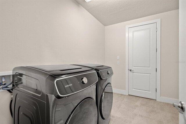 laundry room with a textured ceiling and washing machine and clothes dryer