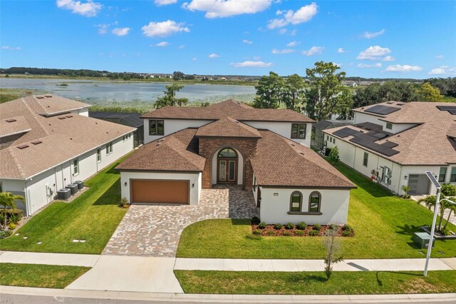 view of front of house featuring a garage, a water view, and a front yard