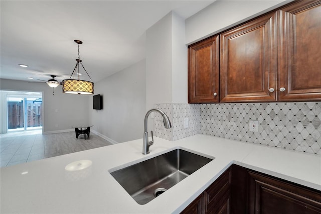 kitchen featuring hanging light fixtures, tasteful backsplash, and sink