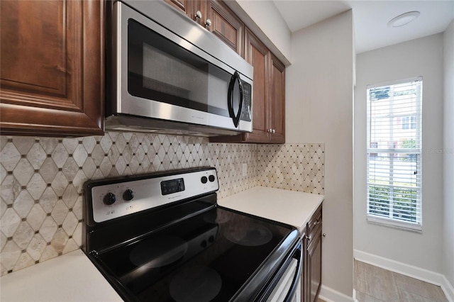 kitchen with stainless steel appliances, decorative backsplash, and a wealth of natural light