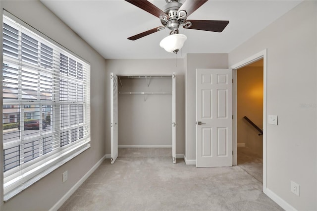 unfurnished bedroom with ceiling fan, a closet, and light carpet