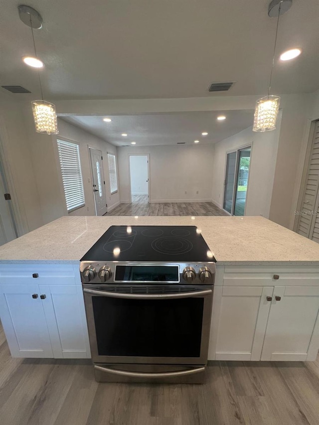 kitchen featuring pendant lighting, light stone counters, white cabinets, and stainless steel electric range oven