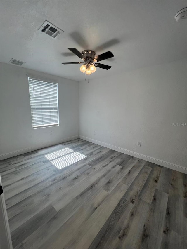 spare room with ceiling fan and light wood-type flooring