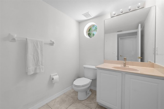 half bathroom with visible vents, toilet, vanity, baseboards, and tile patterned floors