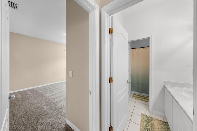 full bath with baseboards, visible vents, tile patterned flooring, and vanity