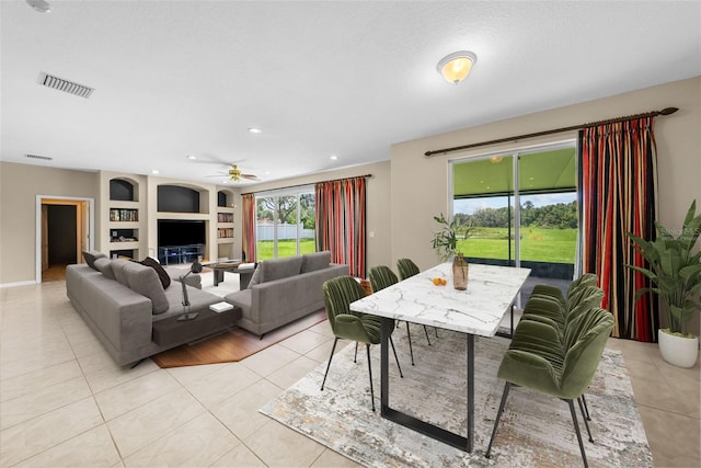 living room with light tile patterned floors, built in shelves, recessed lighting, visible vents, and a ceiling fan