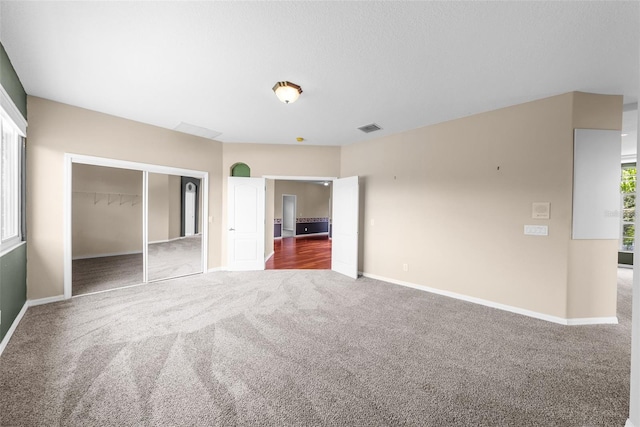 unfurnished bedroom featuring carpet, a closet, visible vents, and baseboards