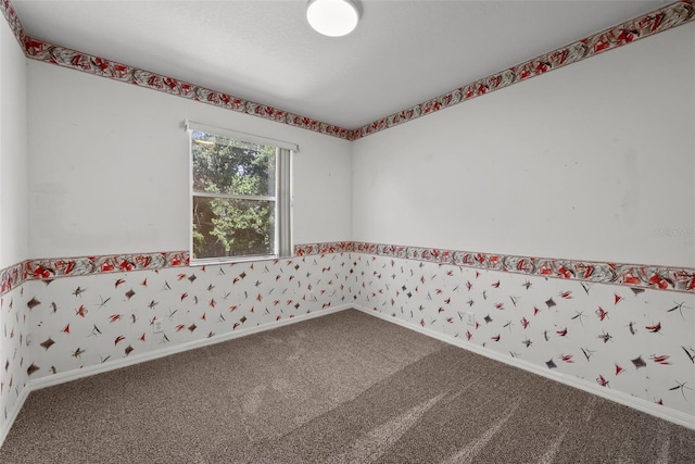 carpeted spare room with baseboards and wallpapered walls