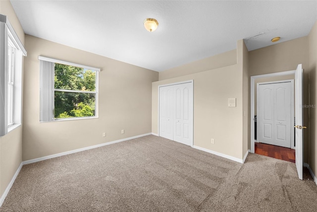 unfurnished bedroom featuring a closet, carpet flooring, and baseboards