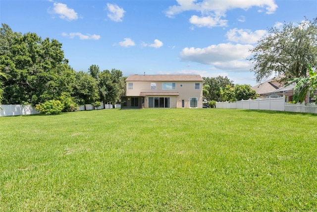 back of house with fence, a lawn, and stucco siding