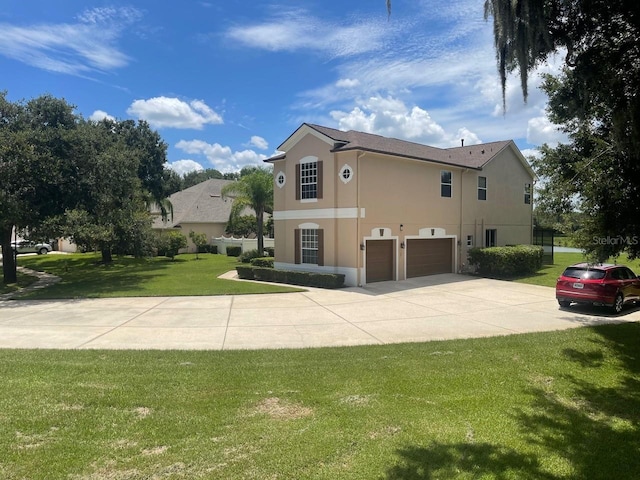 view of side of home with driveway, a yard, an attached garage, and stucco siding