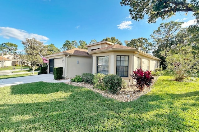 view of side of property featuring a yard, stucco siding, concrete driveway, and a garage