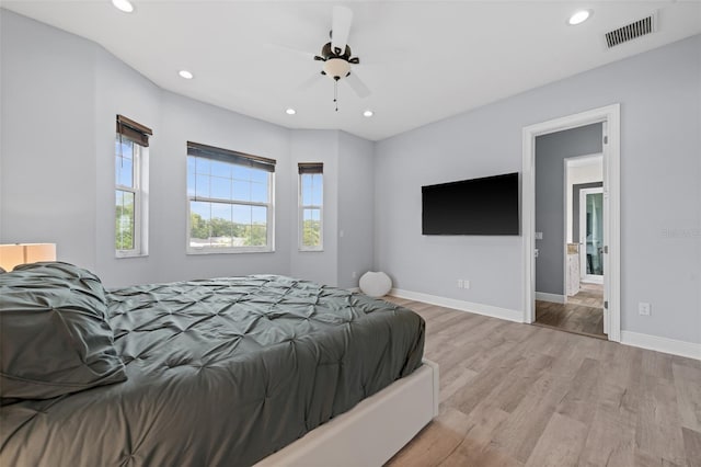 bedroom featuring connected bathroom, light hardwood / wood-style flooring, and ceiling fan