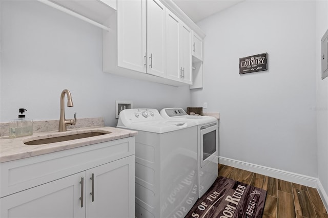 washroom with cabinets, washing machine and dryer, and sink