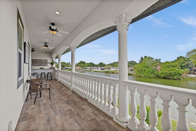 exterior space featuring a water view, exterior bar, and ceiling fan